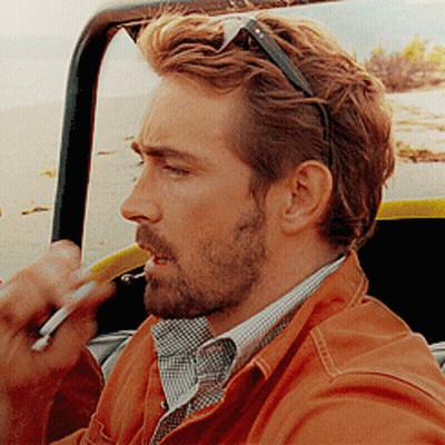 A Man With A Beard And Sunglasses Is Smoking A Cigarette GIF