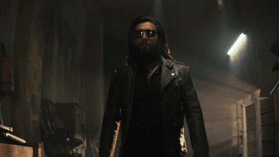 A Man With A Beard And Sunglasses Is Standing In A Hallway GIF
