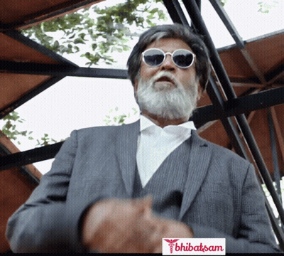 A Man With A Beard And Sunglasses Is Standing In Front Of A Sign That Says ' Bhubasam ' On It GIF
