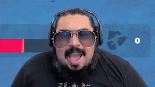 A Man With A Beard And Sunglasses Is Wearing Headphones And Saying Eso . GIF