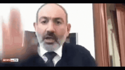 A Man With A Beard And Tie Is Talking On A Video Call With News Tv . GIF