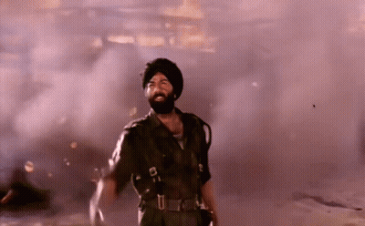 A Man With A Beard And Turban Is Standing In A Smokey Room GIF