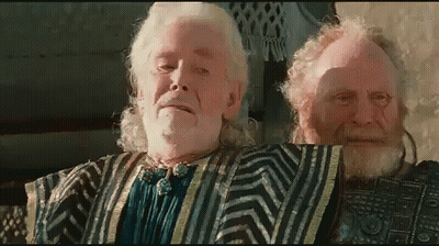 A Man With A Beard And White Hair Is Standing Next To Another Man With A Beard GIF