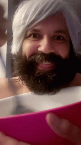A Man With A Beard And White Hair Is Taking A Picture Of Himself GIF