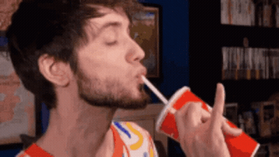 A Man With A Beard Drinking From A Red Cup With A Straw GIF