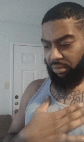 A Man With A Beard Has A Tattoo On His Chest That Says ' A ' On It GIF