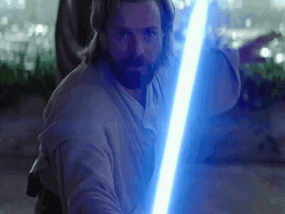 A Man With A Beard Holding A Blue Lightsaber GIF