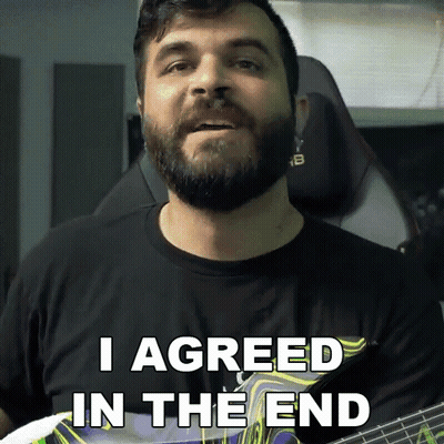 A Man With A Beard Holds A Guitar And Says I Agreed In The End GIF