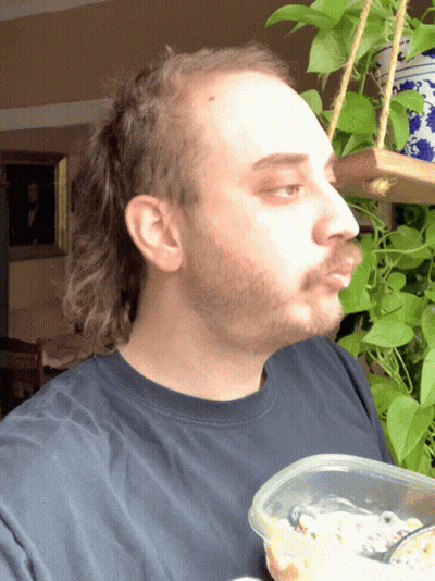 A Man With A Beard Holds A Plastic Container Of Food GIF