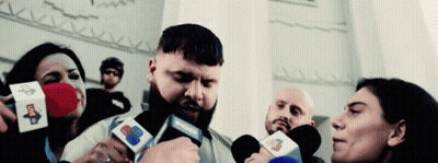 A Man With A Beard Is Being Interviewed By A Group Of People Holding Microphones That Say Cnn GIF