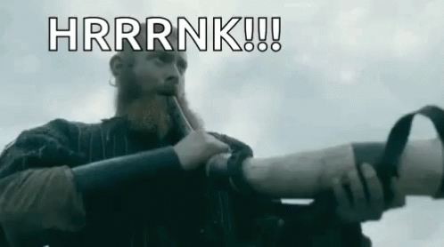 A Man With A Beard Is Blowing A Horn And Saying `` Hrrrnk '' . GIF