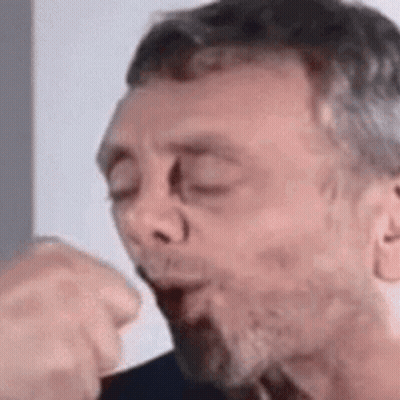A Man With A Beard Is Blowing A Kiss . GIF