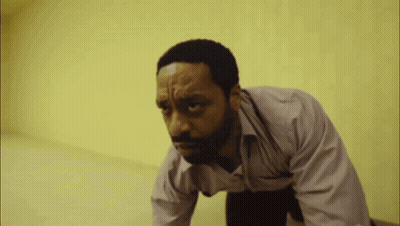 A Man With A Beard Is Crawling On The Floor With His Eyes Closed GIF