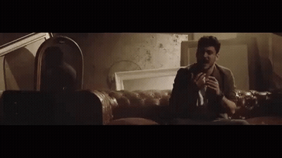 A Man With A Beard Is Crying While Sitting In A Car At Night . GIF