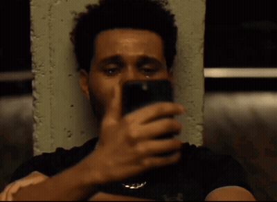 A Man With A Beard Is Crying While Sitting Next To A Concrete Wall . GIF