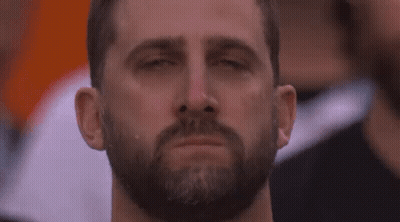 A Man With A Beard Is Crying With His Eyes Closed In A Crowd Of People . GIF