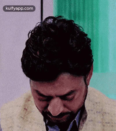 A Man With A Beard Is Crying With His Eyes Closed In A Room . GIF