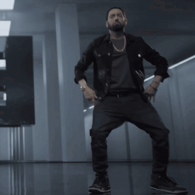 A Man With A Beard Is Dancing In A Room GIF