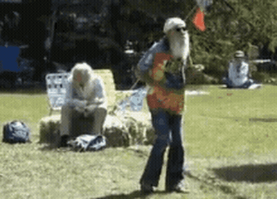 A Man With A Beard Is Dancing In The Grass GIF