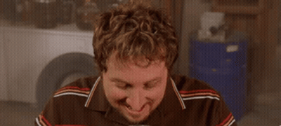 A Man With A Beard Is Drinking A Beer From A Mug . GIF