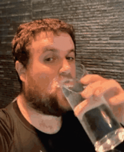A Man With A Beard Is Drinking From A Glass GIF