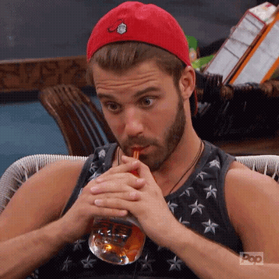 A Man With A Beard Is Drinking From A Glass Through A Straw . GIF