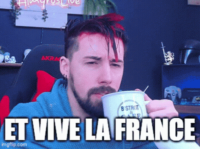 A Man With A Beard Is Drinking From A Mug That Says " Et Vive La France " On It GIF