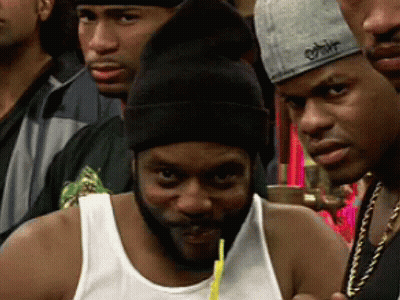 A Man With A Beard Is Drinking From A Straw In A Crowd Of People GIF