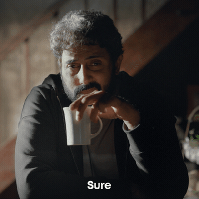 A Man With A Beard Is Drinking From A White Mug And The Word Sure Is On The Bottom GIF