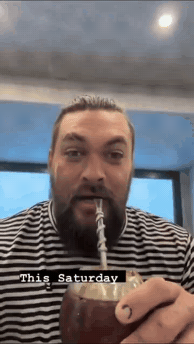 A Man With A Beard Is Drinking Through A Straw From A Coconut . GIF