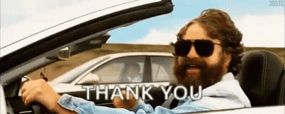 A Man With A Beard Is Driving A Car And Says `` Thank You '' . GIF