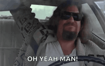A Man With A Beard Is Driving A Car With His Arms In The Air And Saying `` Oh Yeah Man '' . GIF