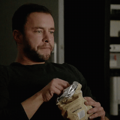 A Man With A Beard Is Eating A Bag Of Chips With A Fork GIF