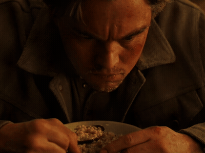 A Man With A Beard Is Eating A Plate Of Food With A Spoon GIF
