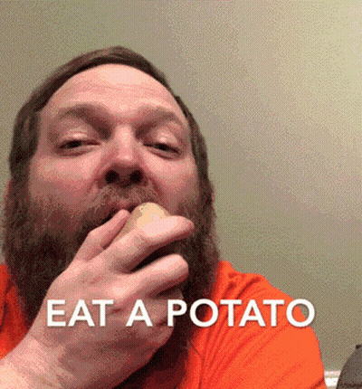 A Man With A Beard Is Eating A Potato With The Words " Eat A Potato " Above Him GIF