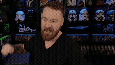 A Man With A Beard Is Flexing His Muscles In Front Of A Shelf Full Of Storm Trooper Helmets GIF