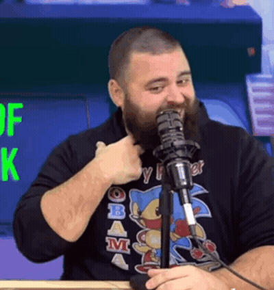 A Man With A Beard Is Giving A Thumbs Up While Talking Into A Microphone . GIF
