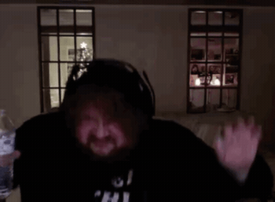 A Man With A Beard Is Giving An Ok Sign In Front Of A Christmas Tree . GIF