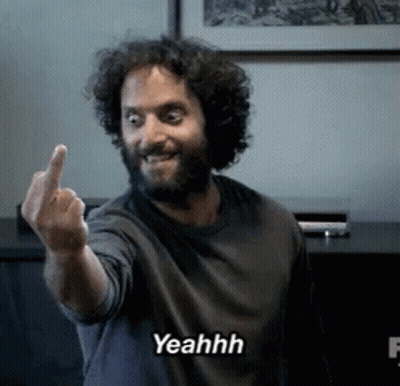 A Man With A Beard Is Giving The Middle Finger And Says Yeahh On The Bottom GIF