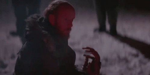 A Man With A Beard Is Holding A Bloody Hand In The Dark GIF