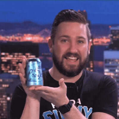 A Man With A Beard Is Holding A Can Of Soda That Says " Old Rock " GIF