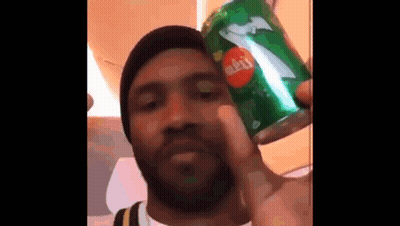 A Man With A Beard Is Holding A Can Of Sprite . GIF