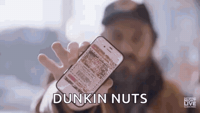 A Man With A Beard Is Holding A Cell Phone In His Hand . GIF