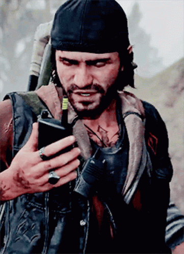 A Man With A Beard Is Holding A Cell Phone In His Hand GIF