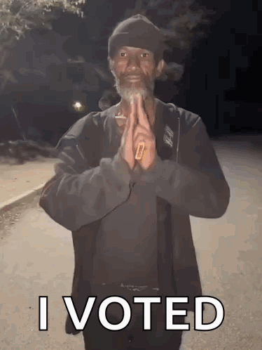A Man With A Beard Is Holding A Cigarette In His Hand And Says " I Voted " GIF