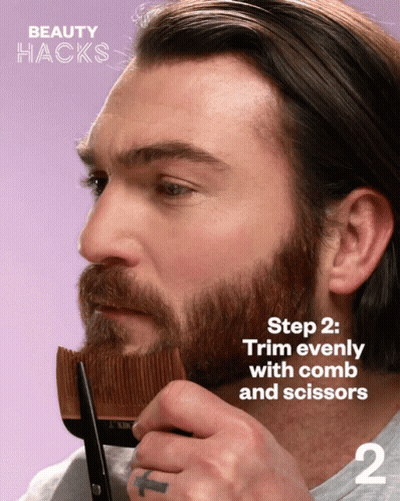 A Man With A Beard Is Holding A Comb And Scissors In His Hand GIF