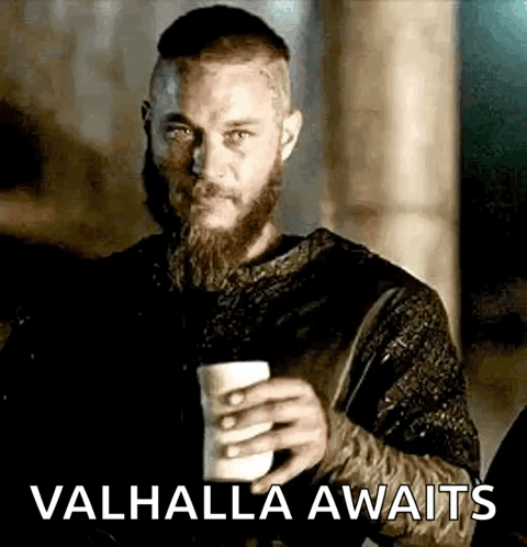 A Man With A Beard Is Holding A Cup Of Coffee And The Words `` Valhalla Awaits '' . GIF