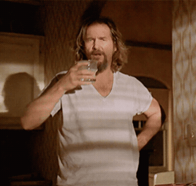 A Man With A Beard Is Holding A Glass Of Water GIF