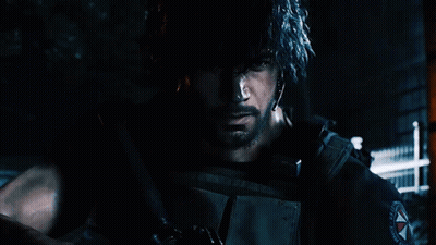 A Man With A Beard Is Holding A Gun In A Dark Room GIF