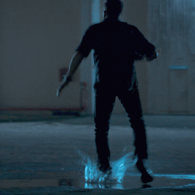 A Man With A Beard Is Holding A Gun In His Right Hand GIF